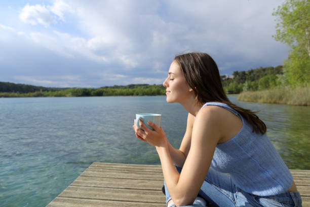 istock Woman relaxing drinking coffee in a lake pier 1316072493