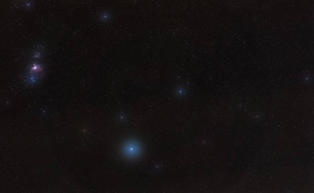 istock Winter night sky with purple Orion nebula, bright blue Rigel star - diffused through some clouds - in bottom lower part, long exposure photo 1316075264