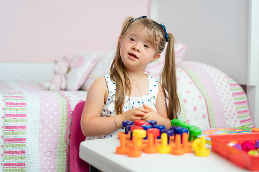 Adorable little girl playing in her room with didactic toys