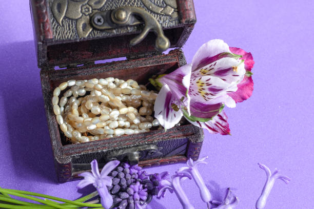On lilac background. Topic: gifts, simple and beautiful jewelry, production of natural pearls.