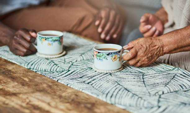 colpo di due persone irriconoscibili che condividono una tazza di caffè - consoling close up senior adult grandparent foto e immagini stock