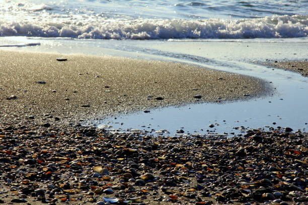 istock Pebbles, breaking waves and a stream on the sunny sandy beach 1316076807