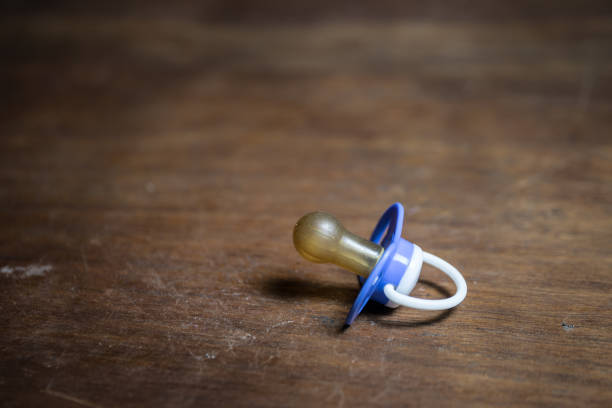 Plastic pacifier on orange background
