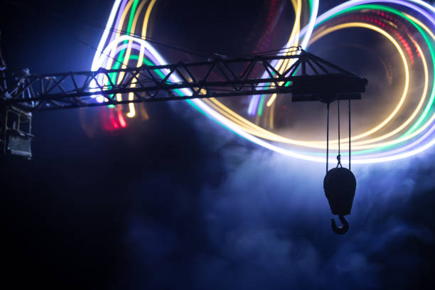 istock Abstract Industrial background with construction crane silhouette over amazing night sky with fog and backlight. Tower crane against the foggy sky at night. 1316077156