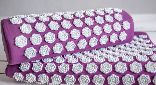 Purple massage acupuncture mat with pillow and white massage tips. Close up massage acupuncture mat with pillow and white massage tips, massage mat for relaxation and treatment. acupuncture mat stock pictures, royalty-free photos & images