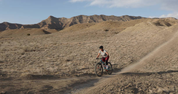 istock Female mountain biker follows desert pathway 1316081175