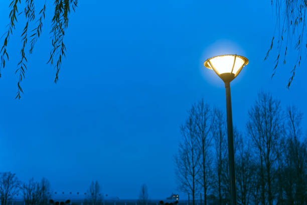 In the evening, a lamppost has been lit under the blue sky