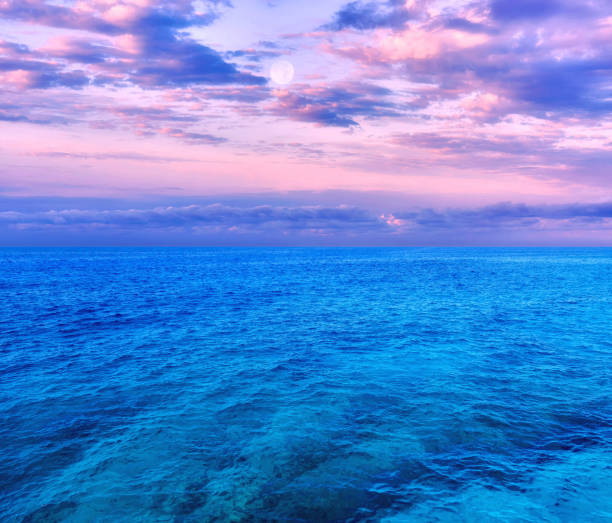istock Pink sunset with full Moon and dramatic clouds over Mediterranean sea in summer 1316083179
