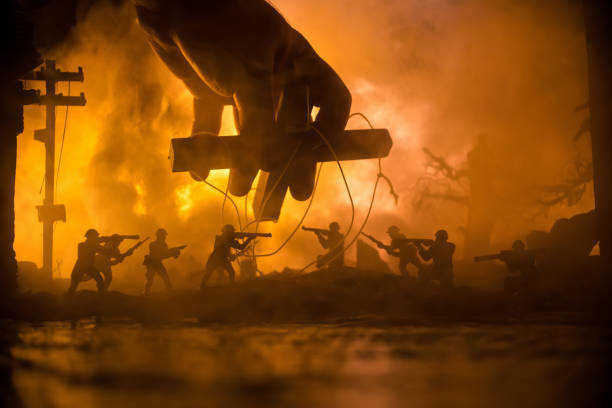 Concept of control. Marionette in human hand. Image on white. Night battle scene. Military fighting silhouettes in destroyed city. Selective focus stock photo
