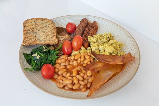 Toast, vegan sausage, tofu eggs, spinach, baked beans, coconut chips, mushrooms and grape tomatoes