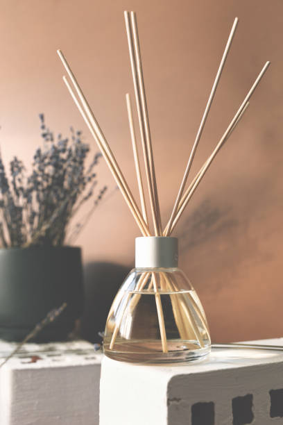 istock Air fragrance with lavender aroma. Glass bottle container with wood stick diffusers. Dry lavender in a dark pot on a brown background. 1316084820