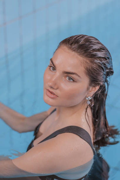 Young woman enjoys swimming pool at day spa
