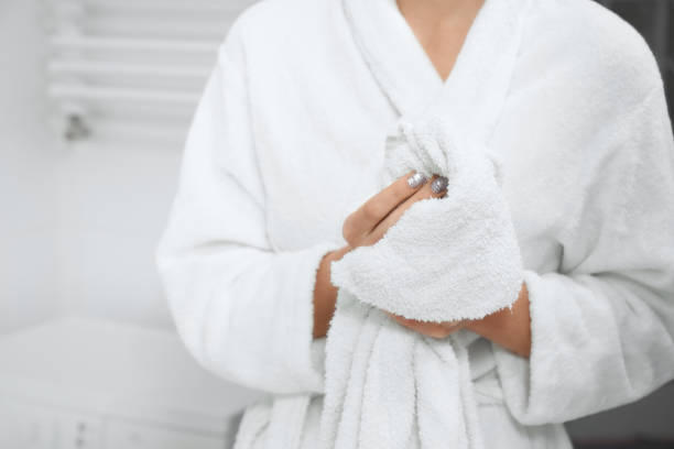 istock Woman in robe standing in bathroom with white towel. 1316086321