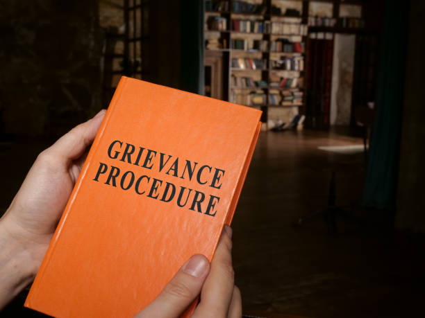 istock Manager holds guide about grievance procedure in the office. 1316089433