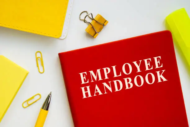 Employee handbook guide on the office desk.