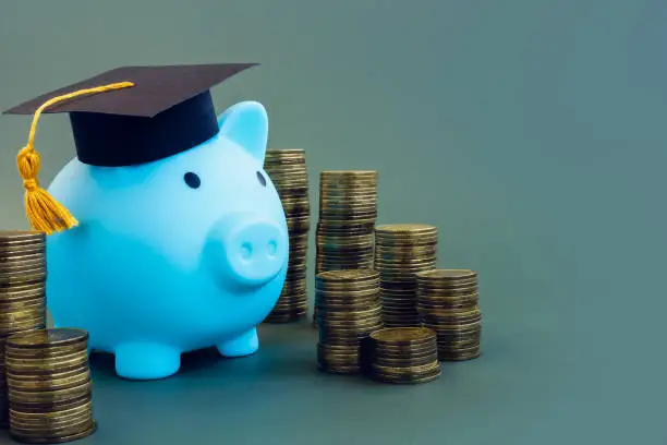 Photo of Savings for college. Piggy bank with graduation cap.