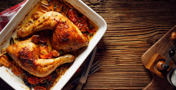 istock Baked chicken quarters in a baking dish on a wooden table top view 1316089898