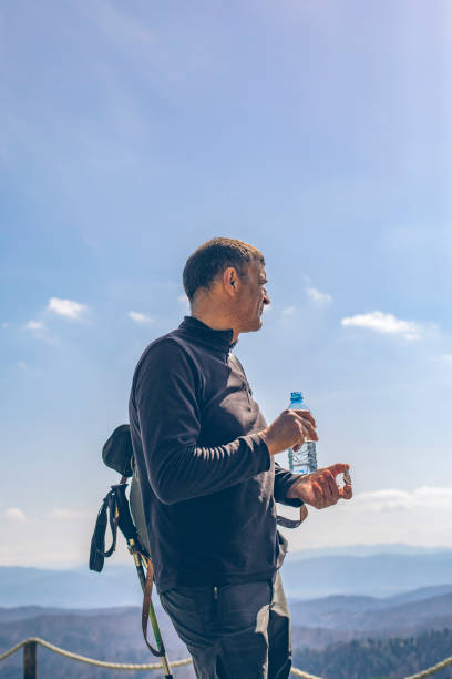 Hiker rests for a snack and drink of water at viewpoint