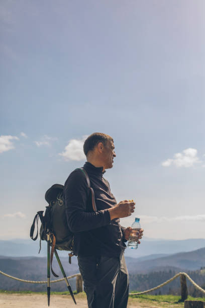 istock Hiker rests for a snack and drink of water at viewpoint 1316090781