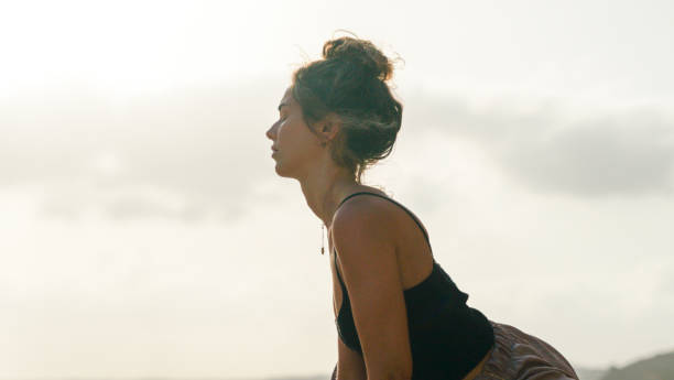 istock Young woman practices yoga on sandy beach 1316090819