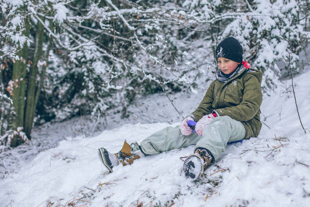 il ragazzo si prepara a slittino lungo il pendio della neve - children only tree area exploration freshness foto e immagini stock