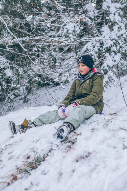 joven se prepara para tirarse por ladera de nieve - children only tree area exploration freshness fotografías e imágenes de stock