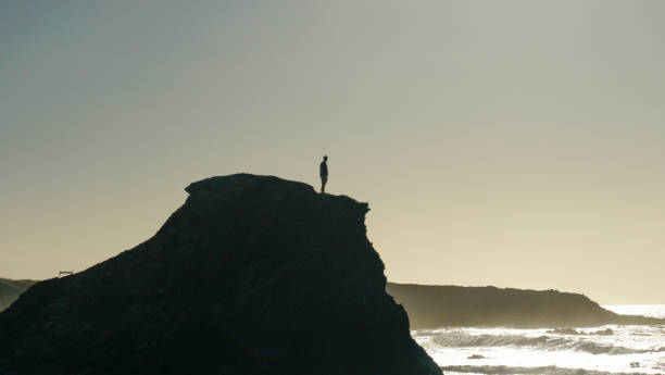 istock Young man stands on coastal cliff in the morning 1316092879