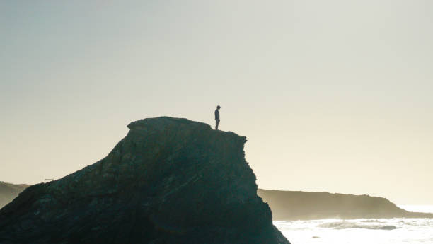 istock Young man stands on coastal cliff in the morning 1316092891