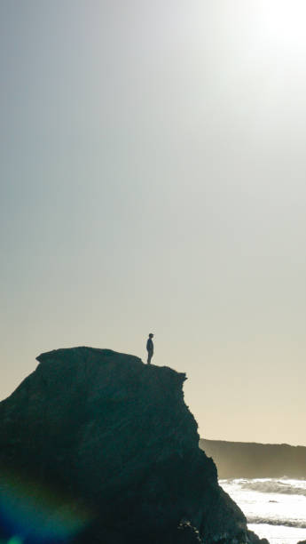 istock Young man stands on coastal cliff in the morning 1316092893