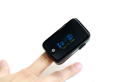 Woman hand introduced in a oximeter to check oxygen levels and pulse because Covid-19 pandemic.