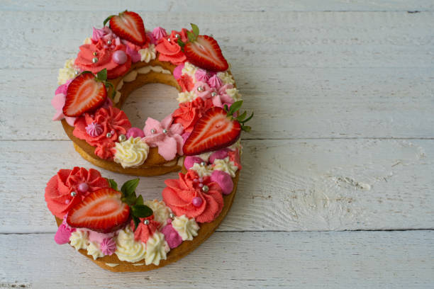 istock Birthday cake. Unusual modern design with strawberries. Spring time. Postcard for the holiday. Beautiful cake in the shape of number 9 on rustic white wooden background 1316093128