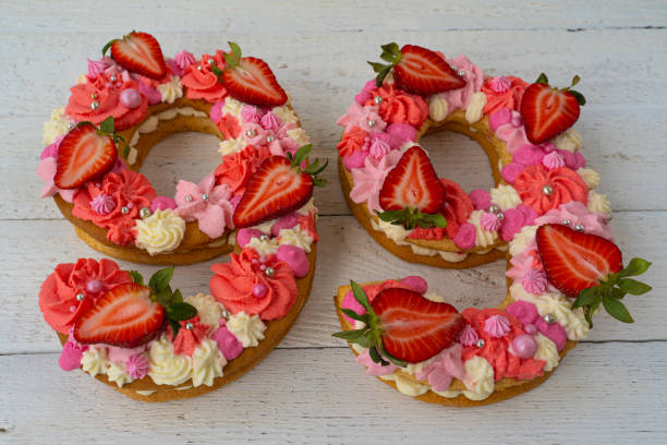 istock Birthday cake. Unusual modern design with strawberries. Spring time. Postcard for the holiday. Beautiful cake in the shape of number 99 on rustic white wooden background 1316093135