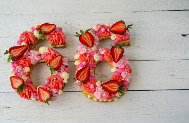 istock Birthday cake. Unusual modern design with strawberries. Spring time. Postcard for the holiday. Beautiful cake in the shape of number 66 on rustic white wooden background 1316093136