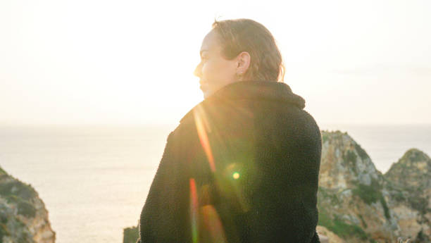 istock Young woman relaxes on coastal cliffs at sunrise 1316094039