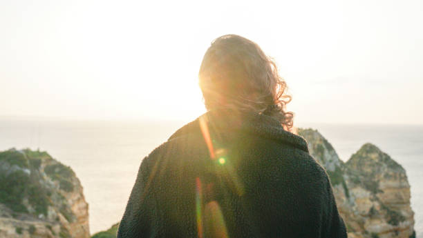 istock Young woman relaxes on coastal cliffs at sunrise 1316094040