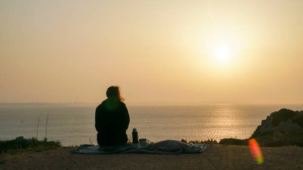 istock Young woman relaxes on coastal cliffs at sunrise 1316094041