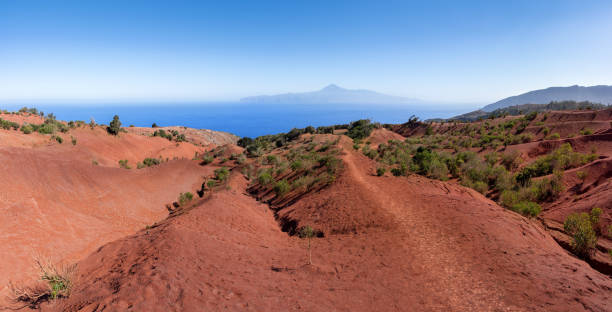 La Gomera, above Agulo - hiking trail through landscape of red earth La Gomera, above Agulo - hiking trail to Mirador de Abrante through landscape of red earth with view to Tenerife island agulo stock pictures, royalty-free photos & images