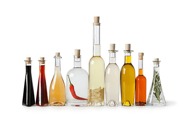 Vegetable fats. Different cooking oils in glass bottles on white background, closeup. Space for text