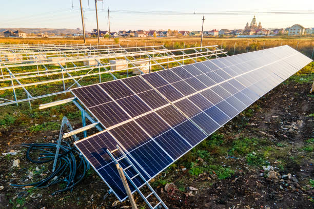 centrale solaire en construction sur le champ vert. assemblage de panneaux électriques pour produire de l’énergie écologique propre. - environmental conservation built structure solar power station building exterior photos et images de collection