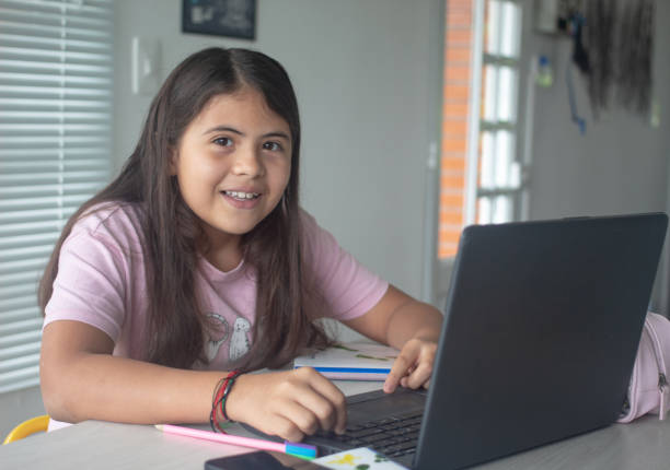 istock Homeschooling - child studying at desk, with laptop looking at camera. New normal 1316100327