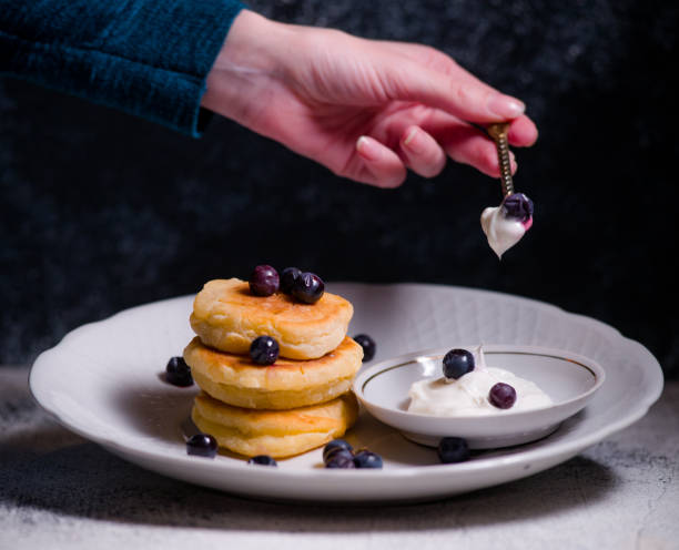 istock Pancakes are small cheesecakes made by hand with hand serving delicious with berries on a beautiful plate with sour cream and chocolate 1316100499