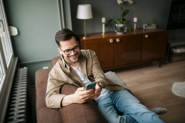istock High angle view of a handsome young Caucasian man using a smart phone at home 1316101173