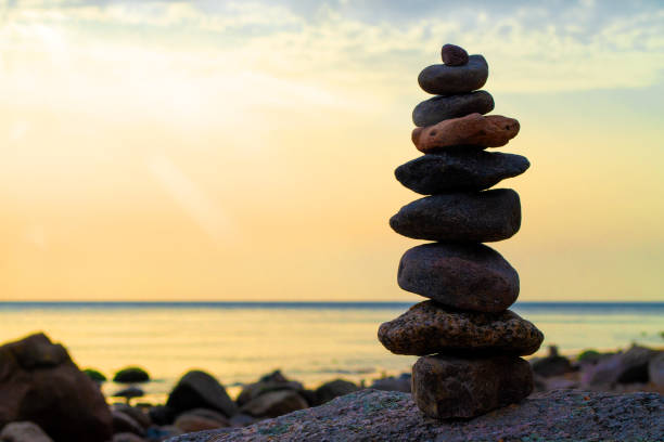istock Stones pyramid on the seashore. Sunset on pebble beach. Balanced life, relax. 1316101191