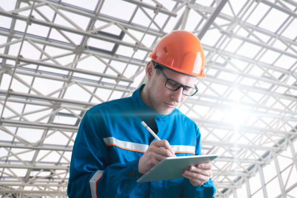 istock male worker in uniform holding and using a tablet 1316102394