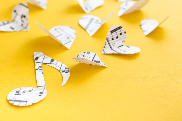 istock Musical notes, clef and hearts cut from paper with musical text on yellow background 1316107337