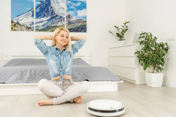 istock Robotic vacuum cleaner cleaning the room while woman resting 1316107560