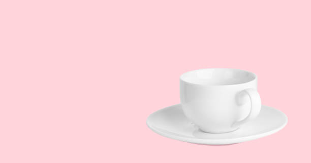 istock White coffee cup on saucer on a pale pink background. 1316107828