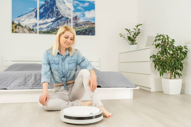 istock Home Cleaning Concept. Modern robot vacuum cleaner cleans hous. New technologies, quick house cleaning automatic robot assistant. Smart appliance for cleaning 1316107981