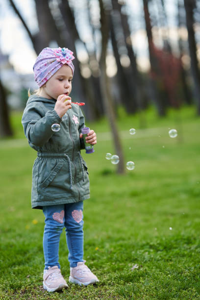 istock Happy girl blowing soap bubbles 1316110659