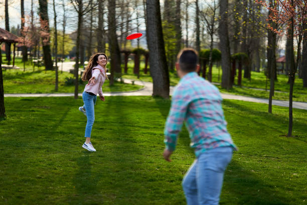 istock Young couple playing freesbie in the park 1316111431